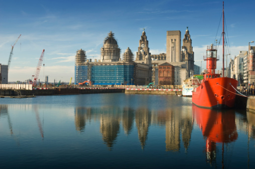 The Royal Liver Building with its clock tower and liver bird towering above other the Open Eye Gallery on Mann Island, Liverpool, England, UK