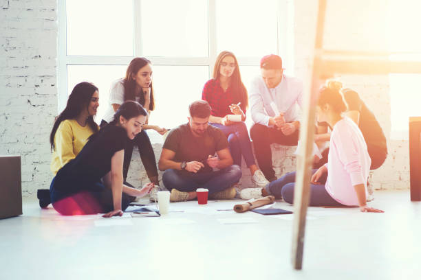 istock Young creative architects cooperating on creating graphic of planning sitting in new office and discussing ideas for successful project.Male and female employees thinking about solving working problem 905135758