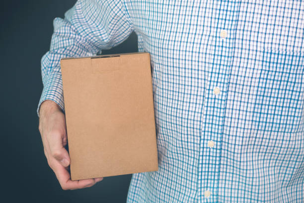 istock Man holding cardboard box package for mock up design 905137988