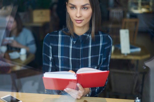 istock Portrait of attractive prosperous administrative manager checking working schedule in notepad sitting in cafe indoors, young student doing homework preparing for exams concentrated on learning 905138992