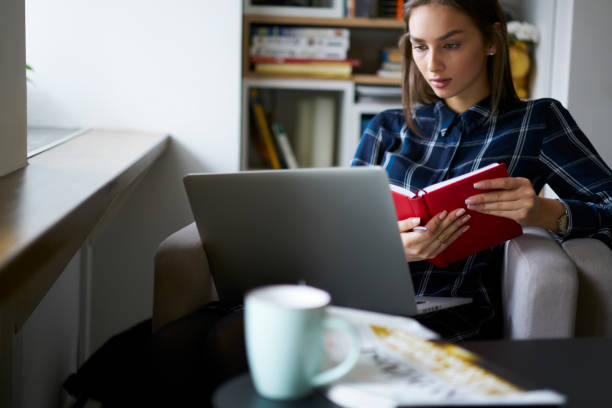 istock Cropped image of concentrated female journalist with notebook for notes watching interesting webinar on modern laptop device connecting to 4G internet sitting in coworking space during free time 905139042