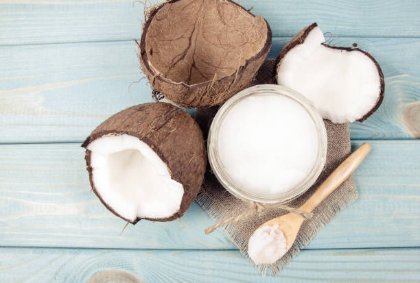 istock Coconut oil and fresh coconuts on a wooden table. 905143990