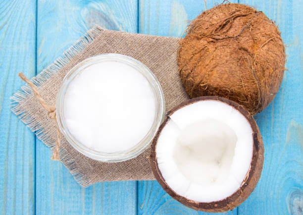 istock Coconut oil and fresh coconuts on a wooden table. 905148498