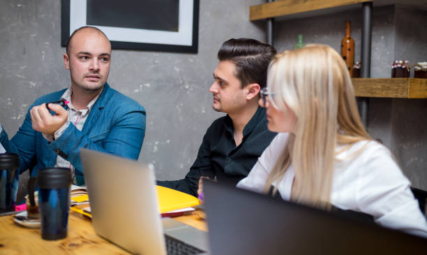 istock Three Businesspeople Working At Laptop In cafe 905148618