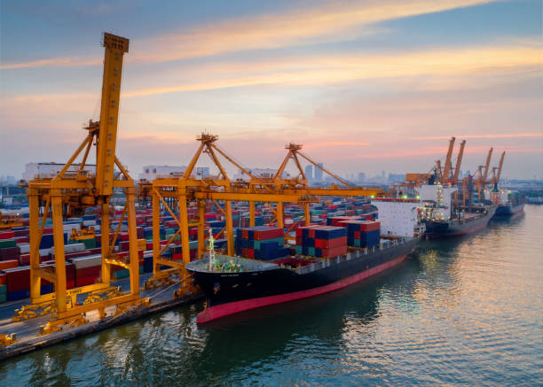 istock Containers yard in port congestion with ship vessels are loading and discharging operations of the transportation in international port.Shot from drone. 905151314