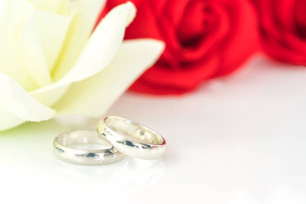 istock Red rose and wedding ring on white 905154994
