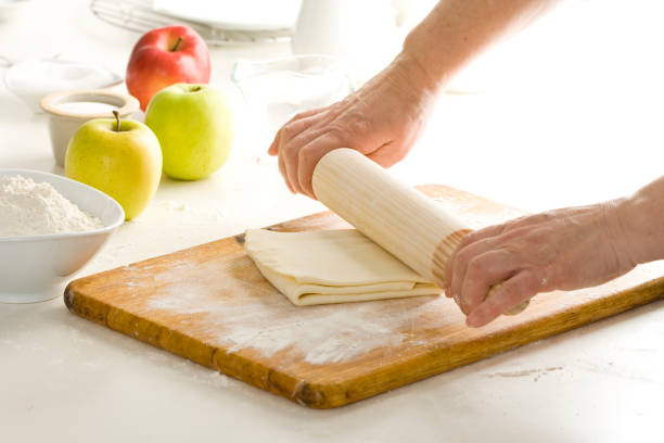 Preparing puff pastry Preparing puff pastry dough with a rolling pin. filo pastry stock pictures, royalty-free photos & images