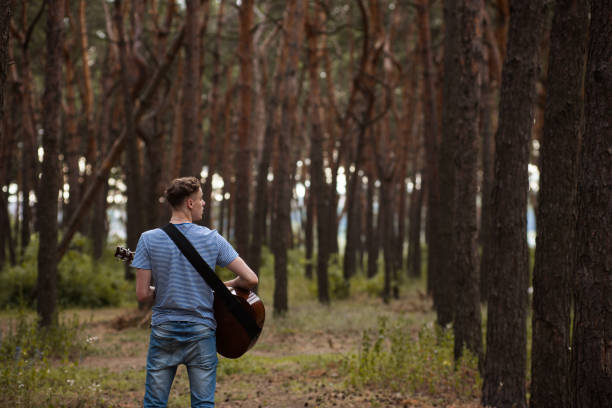 istock Talented guitarist playing forest hiking concept. 905155780