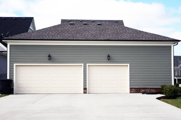 3 car garage attached to a luxury home with prominent driveway stock photo