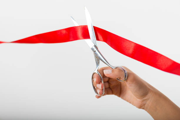istock Woman using scissors to cut opening ribbon 905160146