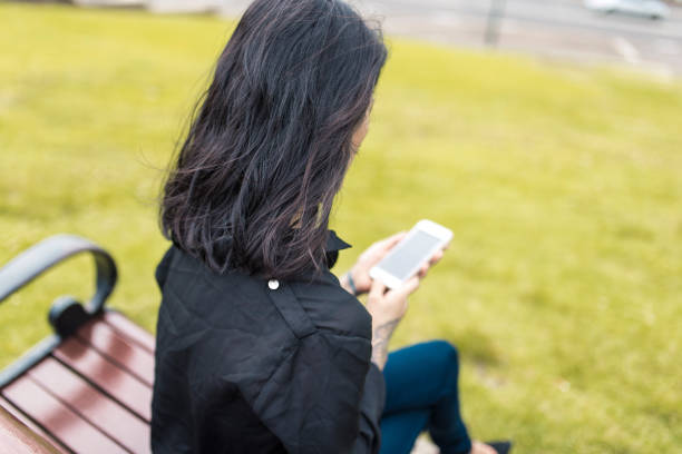 istock Asian woman using smart phone in the park 905177076