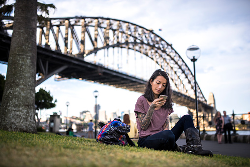 Asian woman relaxing and using smart phone in Sydney
