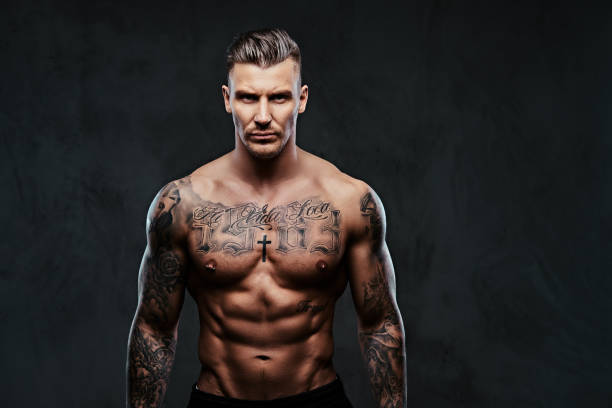 istock A muscular tattooed man on a dark background. 905181194