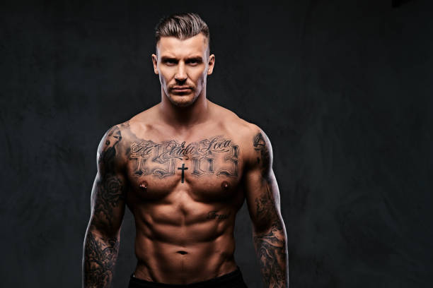 istock A muscular tattooed man on a dark background. 905181892
