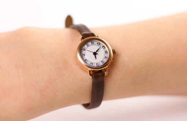 istock Womens gold watch with leather strap on the hand. On a white background 905184290