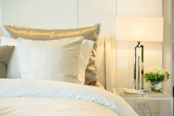 istock Closeup pillows on bed with modern reading lamp at home 905184568