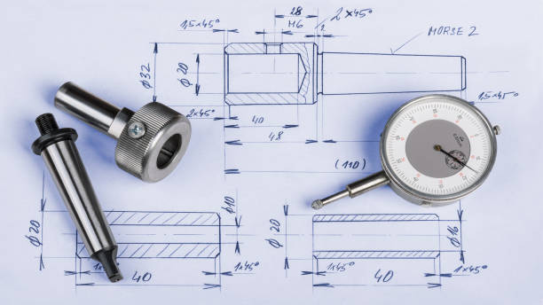 Metal engineering components, gauge and technical drawing Steel machining jigs and dial gauge micrometer laid on the manufacturing documentation micrometer screw gauge stock pictures, royalty-free photos & images