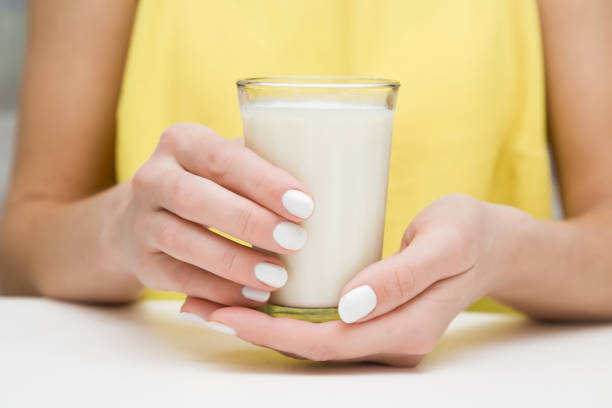 al mattino donna che beve un bicchiere di latte in cucina a casa. concetto di bevanda sana. - milk morning adult women foto e immagini stock