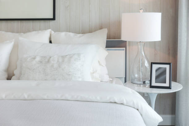 istock Luxury style bedding with puffy pillow and white table lamp in bedroom 905192952