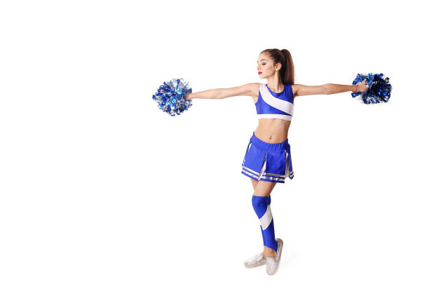 istock Young cheerleader in blue and white suit with pompoms on white background. 905197666