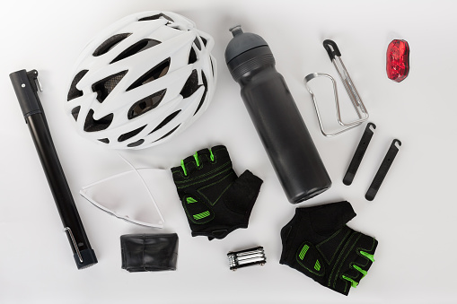 Bike accessories, bike helmet, bike gloves, eyeglasses, tire lever set, hand pump and water bottle in holder