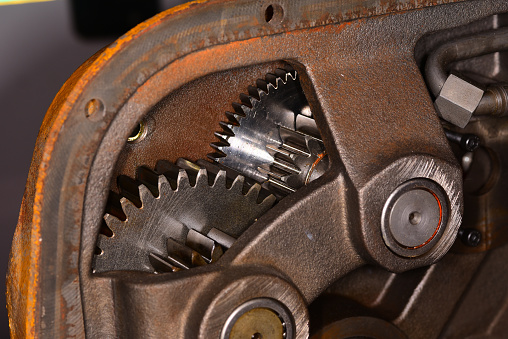 Steel gears meshing together in winch, with teeth polished from use. A support cast into steel housing holds the gear shafts in bearings. Photo taken in Gainesville, Florida. Nikon D750, Nikon 105mm Micro lens and SB21 flash.