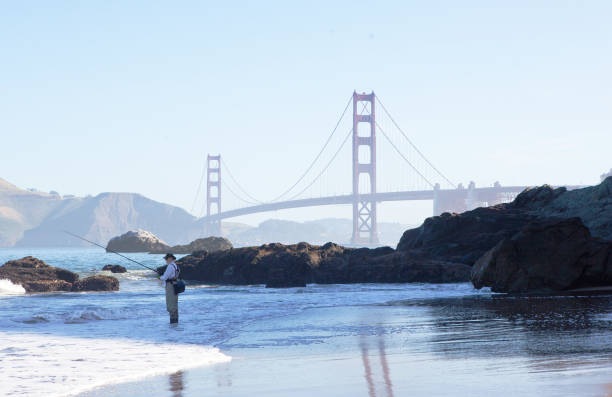 ゴールデン ゲート ブリッジの近くにパン屋浜の漁師。 - baker beach ストックフォトと画像