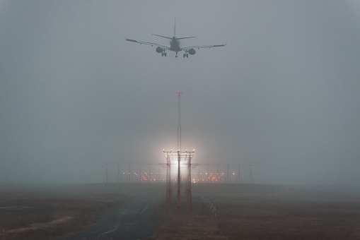 A passenger jet on final approach in heavy fog.