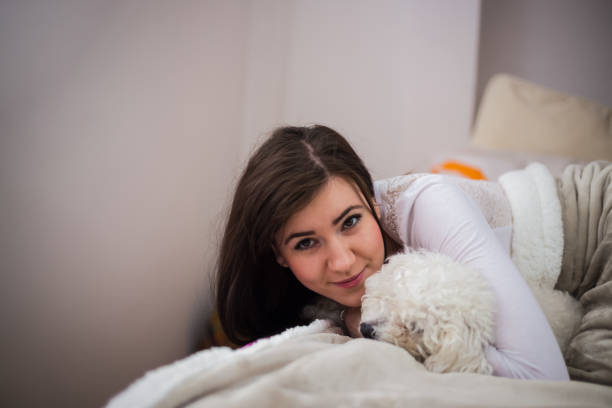 istock Young woman with her dog in a bed. 905212924