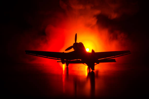 istock German Junker (Ju-87) jet-propelled model plane in possession. Dark orange fire background. War scene. Selective focus (Difference position placement) 905214062
