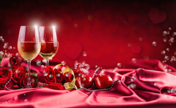 istock Valentines or wedding concept. Wine cups red roses and romantic setting for two in red. Greeting card for jubilee or aniversary 905216932
