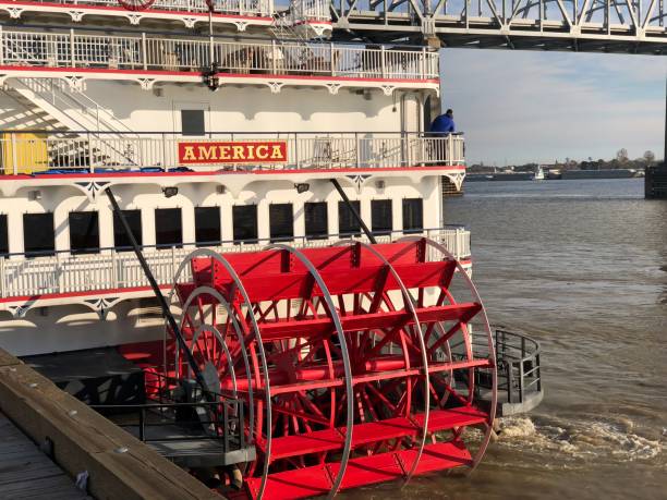 мосты пересекают реку миссисипи в новом орлеане, штат луизиана.  лодка paddlewheel river возглавляет вниз по реке от берега.  мосты соединяют восточ� - ship river east river sky стоковые фото и изображения