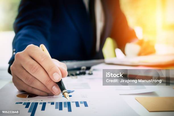 Businessman Pen Pointing Graph Chart In This Mounth And Using La Stock Photo - Download Image Now