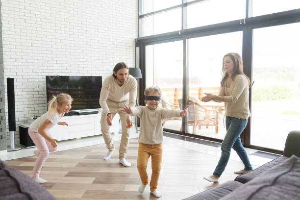 istock Blindfolded little boy playing hide and seek game with family 905222702