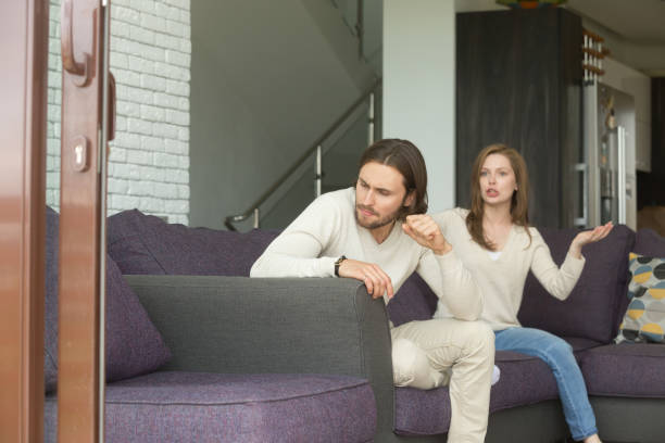 istock Frustrated angry young man sitting on couch ignoring arguing wife 905222774