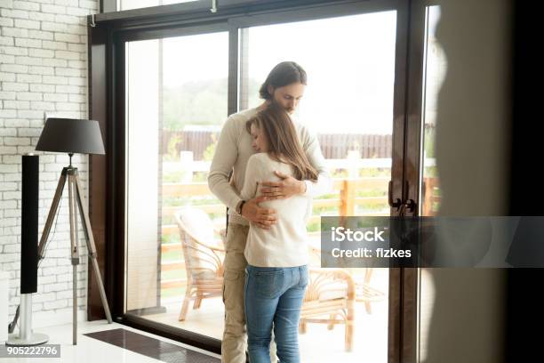 Giovane Uomo E Donna Abbracciati In Piedi A Casa Riconciliazione Coppia - Fotografie stock e altre immagini di Relazione di coppia