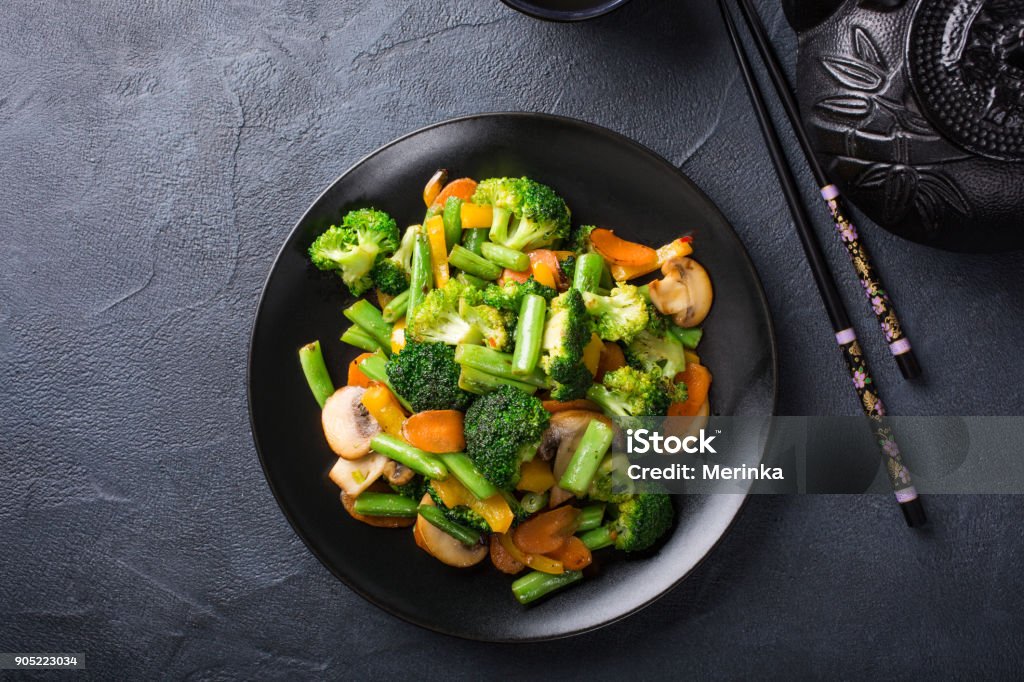 Stir fried vegetables Hot stir fried vegetables on black plate. Healthy asian food concept with copy space. Vegetable Stock Photo