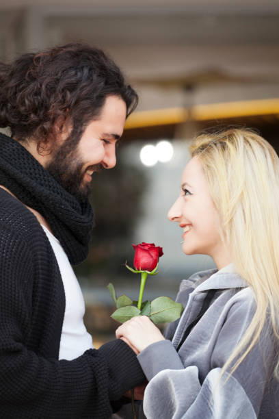 istock Smiling couple outdoors with red rose 905226744