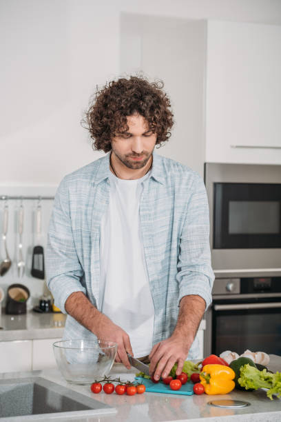 istock handsome man cutting vegetables for salad 905228930
