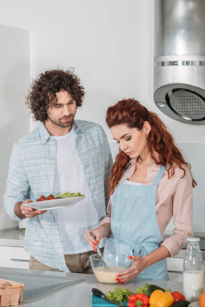 istock girlfriend preparing batter and boyfriend holding plate 905229484