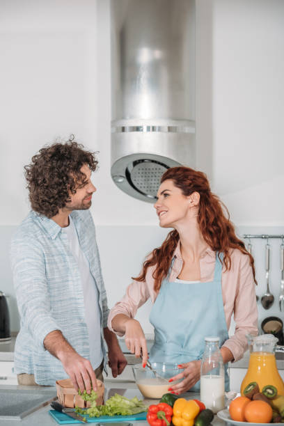 istock girlfriend preparing batter and looking at boyfriend 905229596