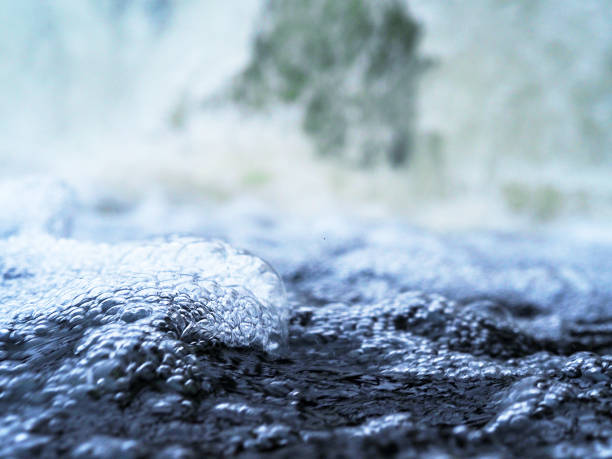 istock Winter waterfall, bubbling fast and turbulent water flow. Bubbles on water close-up. Selective focus 905242536