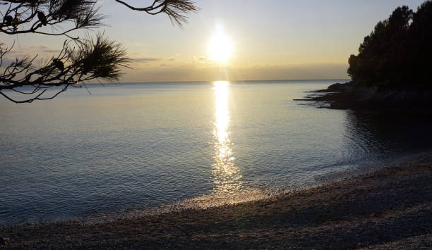 istock Sunset on blue lagoon and pebble beach 905243572