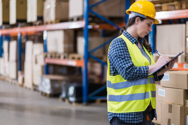 istock Female Warehouse Supervisor Writing On Clipboard While Standing In Warehouse 905251122