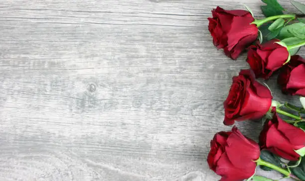 Photo of Beautiful Red Roses Over Rustic Wooden Background