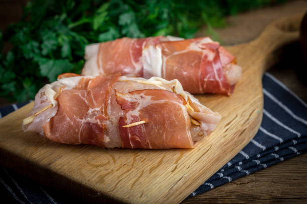 istock Raw chicken breast stuffed with champignon wrapped with bacon. 905254544