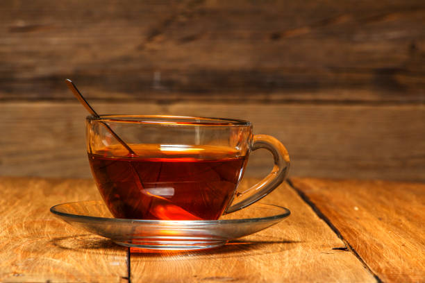 istock Tea in a glass cup with a kettle on a wooden table. Close-up. 905262258