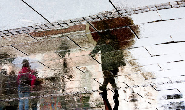 istock Rain reflection silhouette shadow of people 905262458
