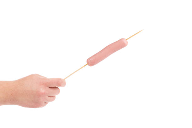 istock Hand holds sausage on stick. 905267878