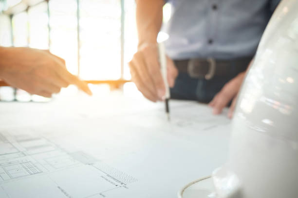 istock Image of engineer or architectural project, Close up of hands architects engineering working on blueprint with engineering equipment tool, blurred background 905274254